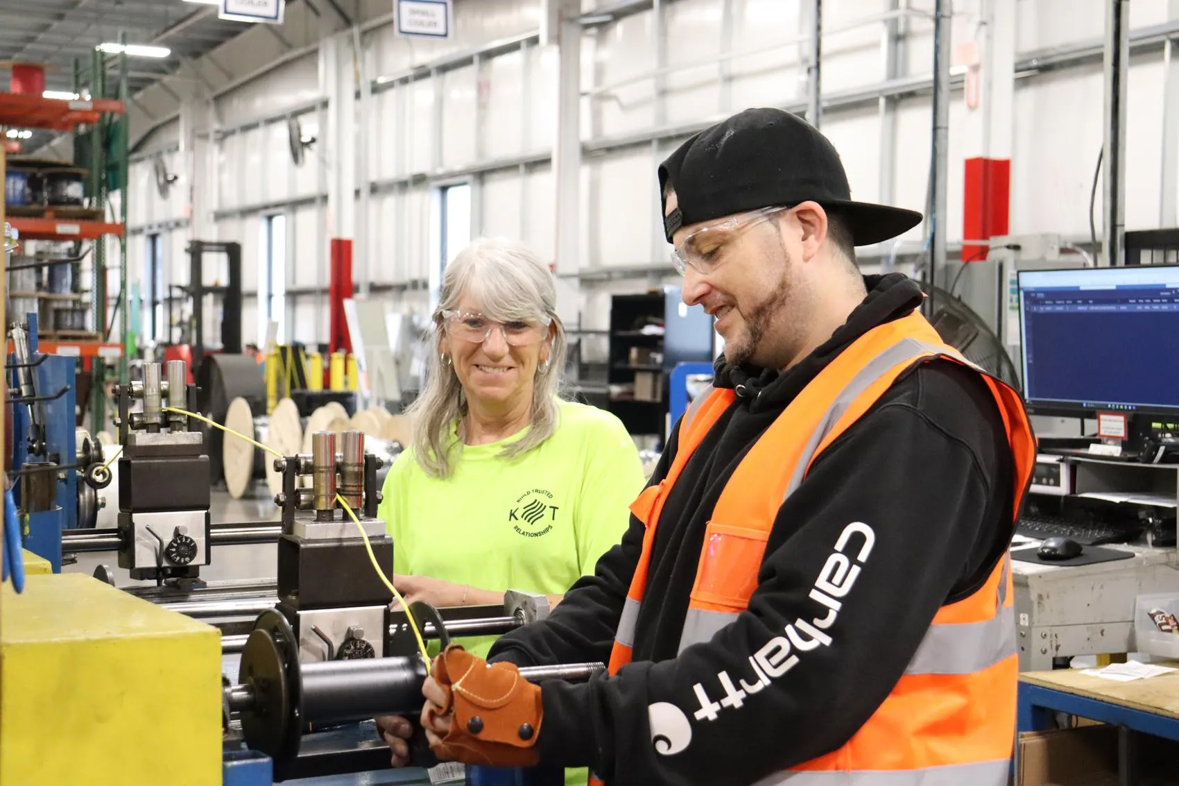 Two KrisTech Wire employees train together on a wire respooling machine inside the company's manufacturing facility. - KrisTech Wire (Photo via Gino Geruntino)