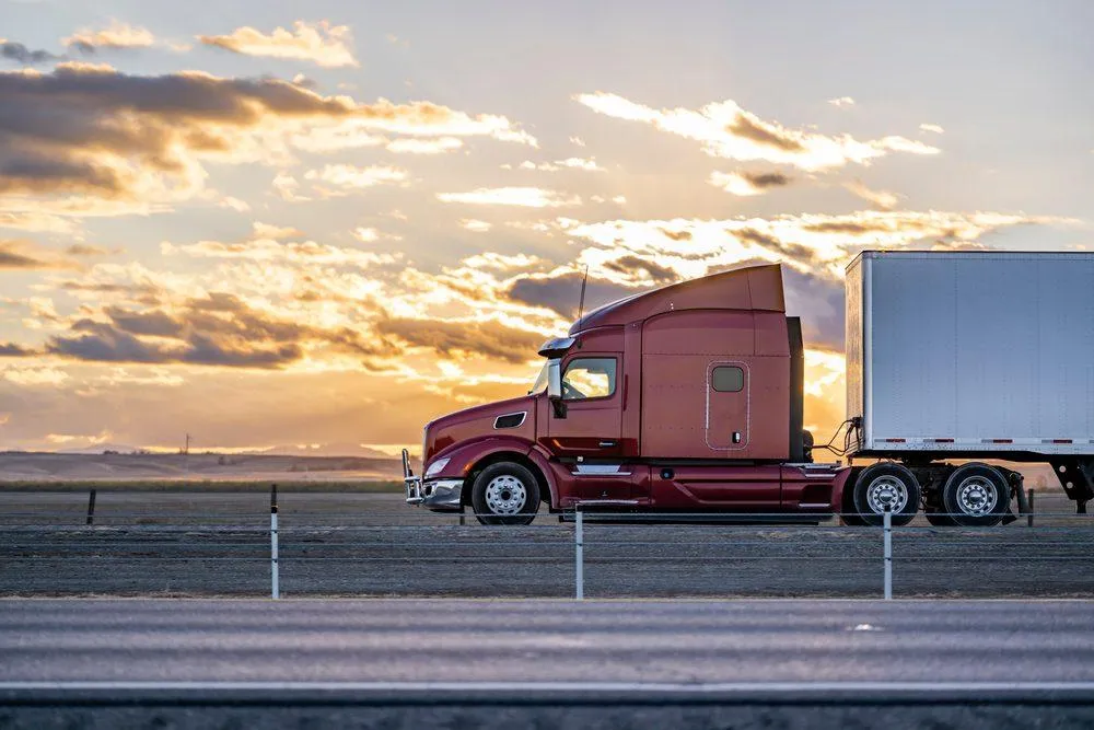 Industrial long-haul truck hauling materials in the sunset. (Photo via Shutterstock)