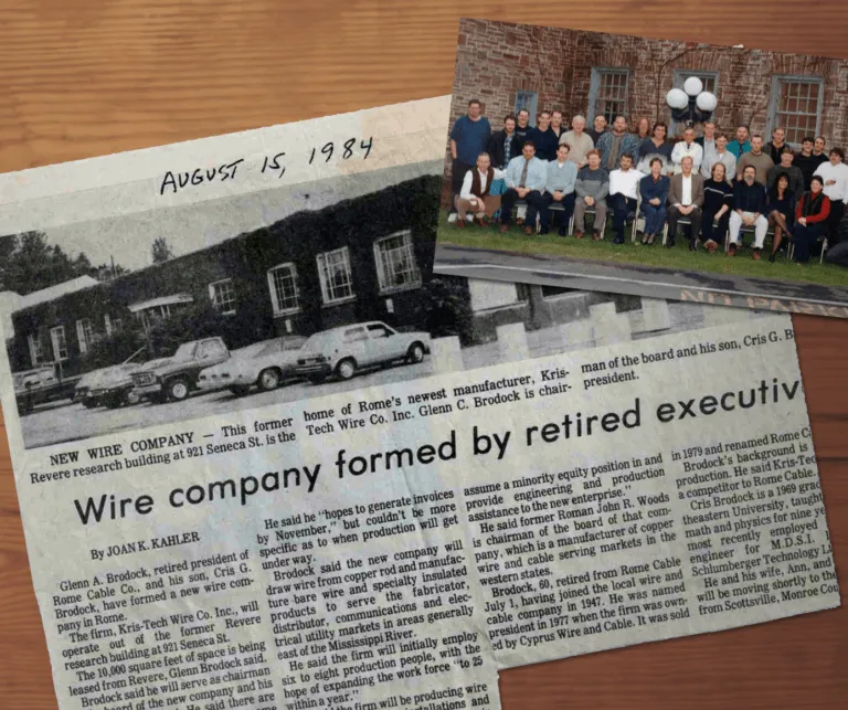 A newspaper cutout from August 14, 1984, highlights KrisTech Wire’s founding, alongside an image of the company’s staff from the late 1990s.