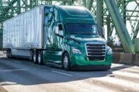 A tractor trailer crosses a bridge on a sunny day. - KrisTech Wire, photo via Shutterstock
