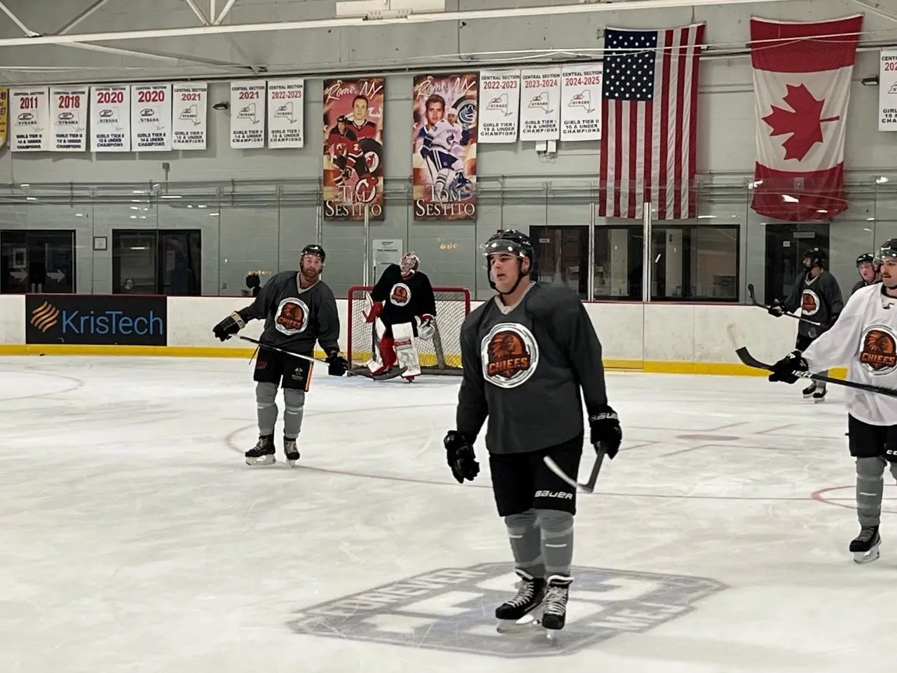 Jugadores de los Copper City Chiefs en el hielo con la pancarta de KrisTech - Foto vía Copper City Chiefs
