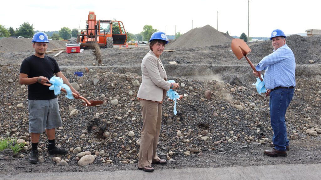 Clark Garcia, Rome Mayor Jackie Izzo, and Jeff Handley throw dirt during Kris-Tech's groundbreaking event.